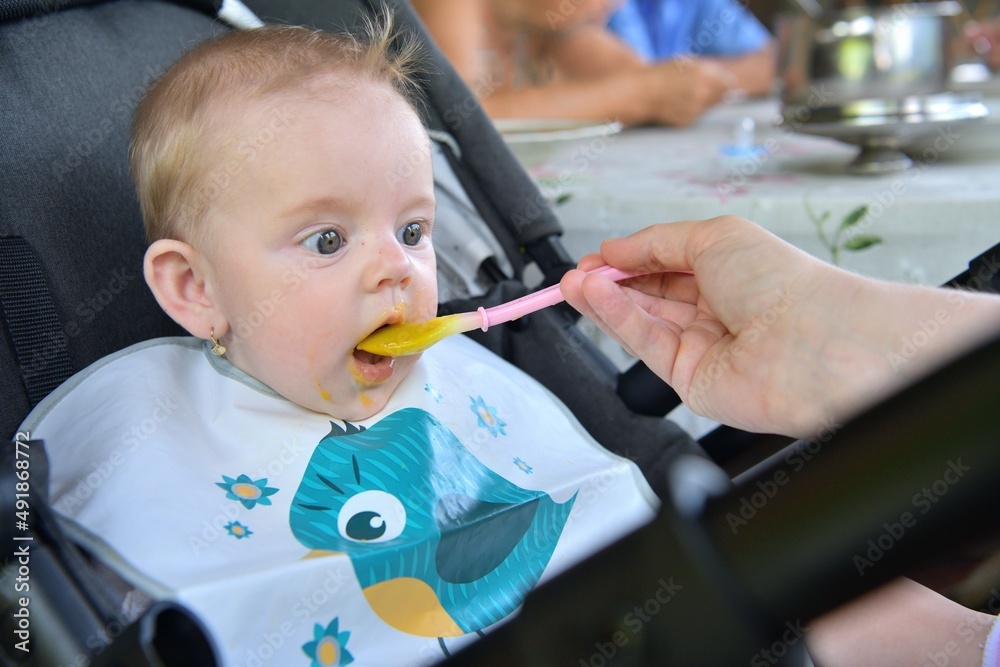 Portrait of a baby's mouth being fed baby gruel