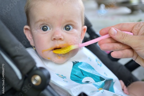Portrait of a baby's mouth being fed baby gruel  photo