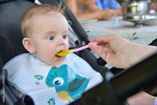 Portrait of a baby's mouth being fed baby gruel  photo