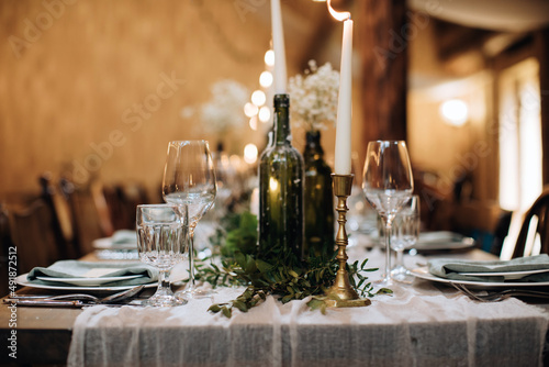 Table decoration for a festive dinner with candles in old bottles