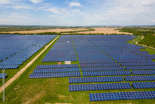 Aerial view of big sustainable electric power plant with many rows of solar photovoltaic panels for producing clean ecological electrical energy. Renewable electricity with zero emission concept