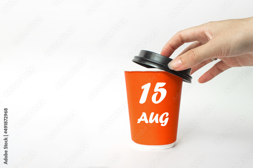 August 15th. Day 15 of month, Calendar date. A woman's hand open black plastic cap of red disposable cardboard coffee paper cup with Calendar Date. Summer month, day of the year concept. August 15th. Day 15 of month, Calendar date. A woman's hand open black plastic cap of red disposable cardboard coffee paper cup with Calendar Date. Summer month, day of the year concept.