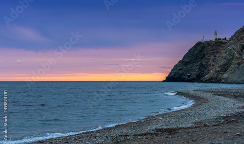 view of La Chucha Beach and the lighthouse of Cabo Sacratif in Andalusia at asunset photo
