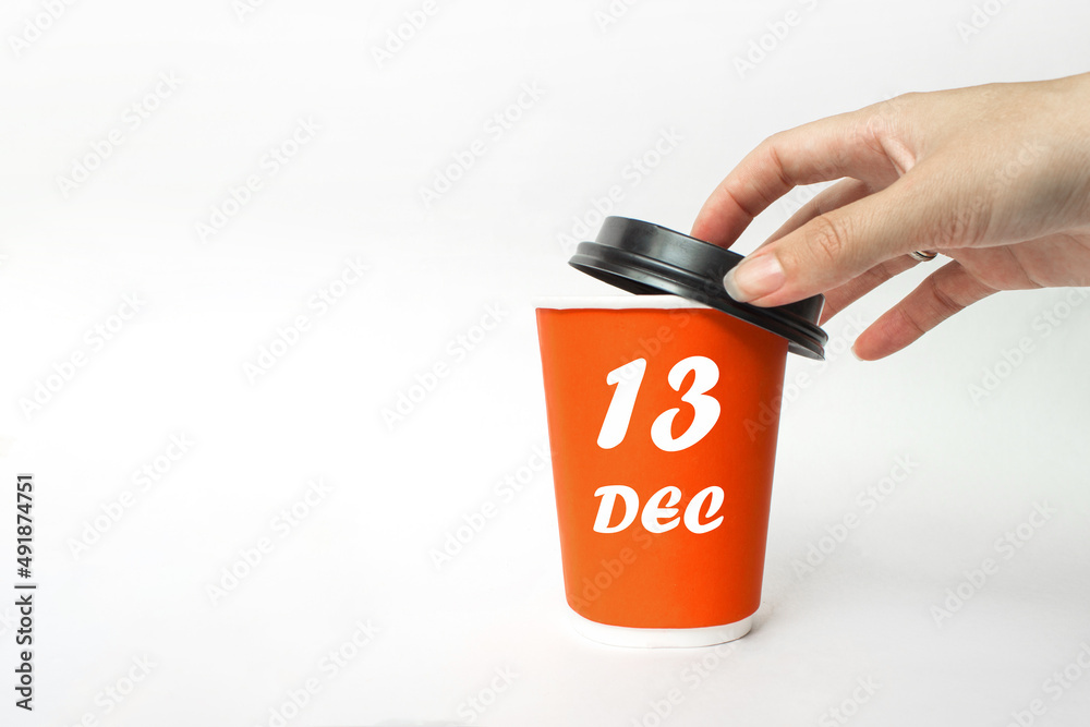 December 13rd. Day 13 of month, Calendar date. A woman's hand open black plastic cap of red disposable cardboard coffee paper cup with Calendar Date. Winter month, day of the year concept. December 13rd. Day 13 of month, Calendar date. A woman's hand open black plastic cap of red disposable cardboard coffee paper cup with Calendar Date. Winter month, day of the year concept.
