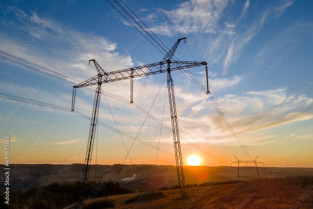 Obraz premium High voltage tower with electric power lines at sunset. Transmission of electricity