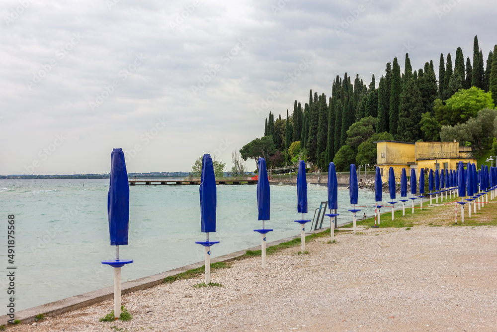 Lake Garda beach with cypress trees, Italy, Lombardy Lake Garda beach with cypress trees, Italy, Lombardy