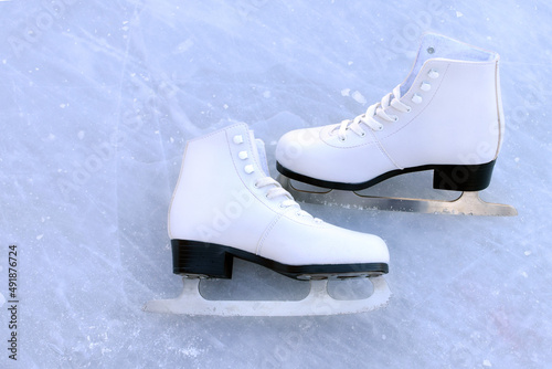 White figured women's skates on the rink. Active recreation concept. Top view, flat lay.