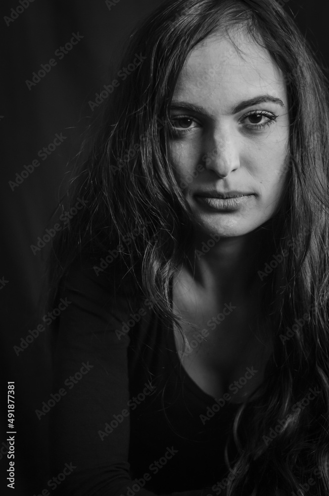 Close up portrait of a beautiful Italian woman with long hair and an intense and seductive gaze	