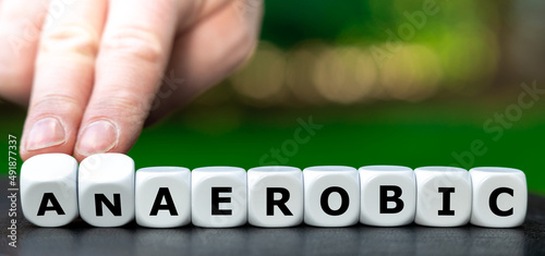 Symbol for aerobic training. Hand turns dice and changes the word anaerobic to aerobic. photo