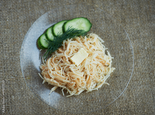 boiled spaghetti with butter on a transparent plate