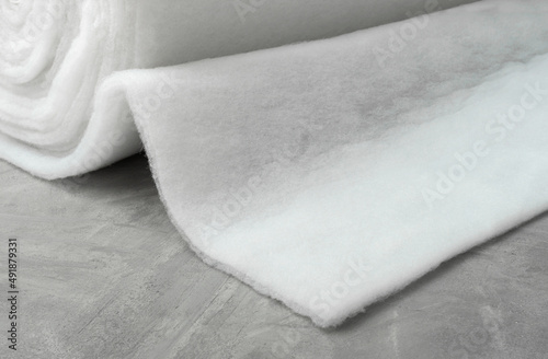Sintepon. Insulation for clothing. Sintepon production. White synthetic fiber on a gray concrete background