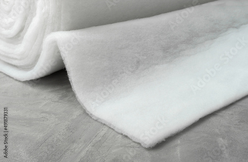 Sintepon. Insulation for clothing. Sintepon production. White synthetic fiber on a gray concrete background