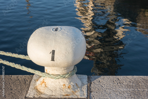 Bollard on the dock with number one and reflections on the water