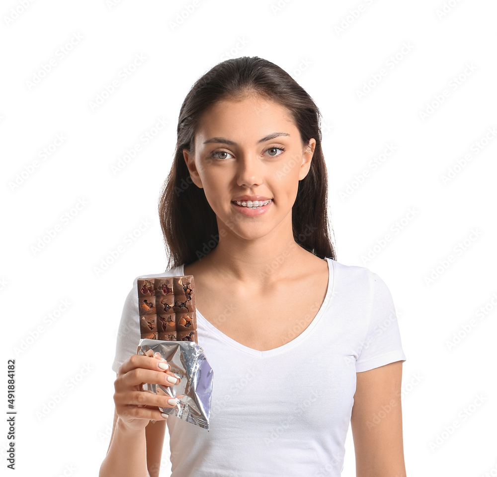 Pretty teenage girl with dental braces and chocolate on white background Pretty teenage girl with dental braces and chocolate on white background
