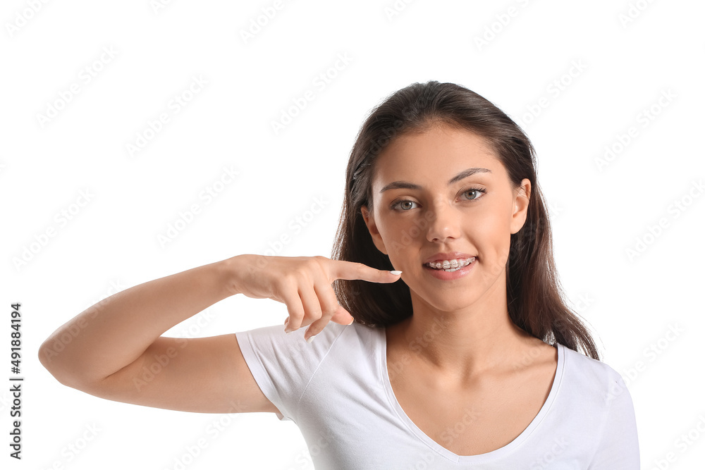 Pretty teenage girl pointing at dental braces on white background Pretty teenage girl pointing at dental braces on white background