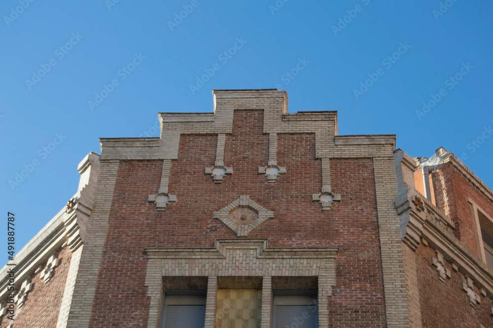cornice of a brick building with windows and ornaments