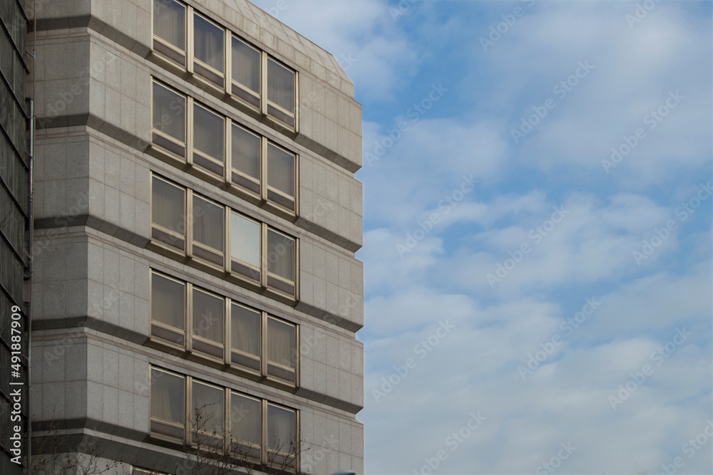 modern building with glass windows on sky with clouds background