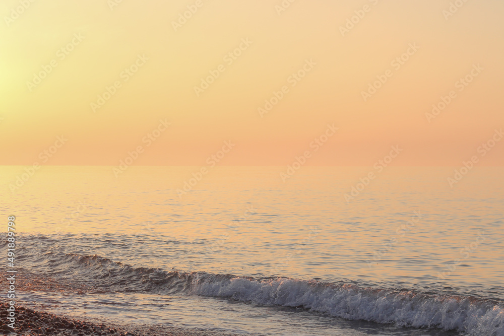 Beautiful sunset on the rocky beach . Soft peaceful water composition