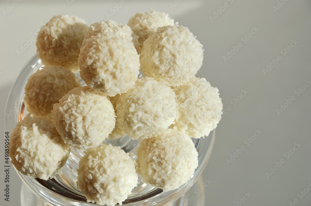 coconut balls. delicious candies with coconut chips. sweet dessert on a light background.
