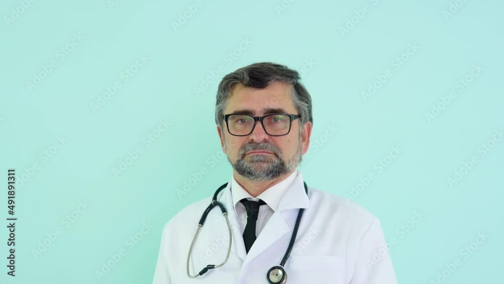 Senior doctor removes a medical mask on blue background. End of quarantine. Stop virus Senior doctor removes a medical mask on blue background. End of quarantine. Stop virus