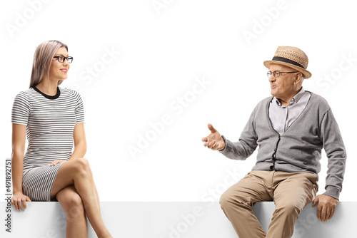 Elderly man talking to a young blond woman seated on a panel