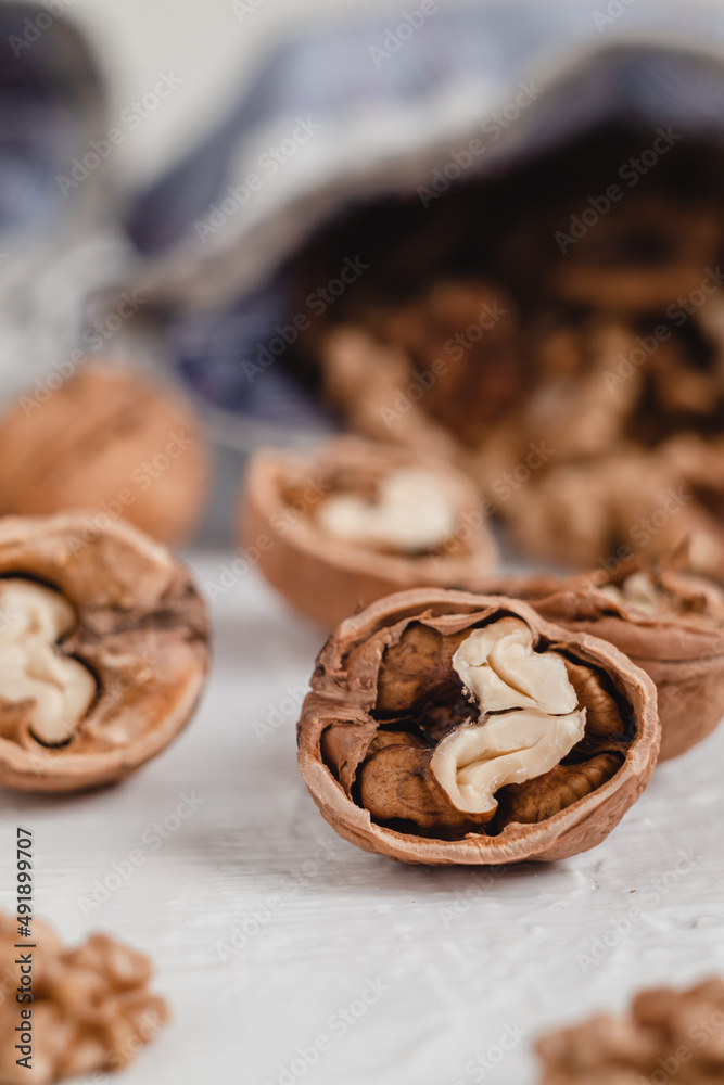 Many walnut kernels close up in eco bag on a white background. Healthy eating concept.