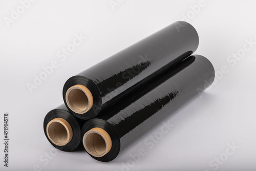 Roll of plastic cling film with black wrap. how long the roll of cling film can stretch is shown. It stands in an isolated environment. It is used in the packaging of products.