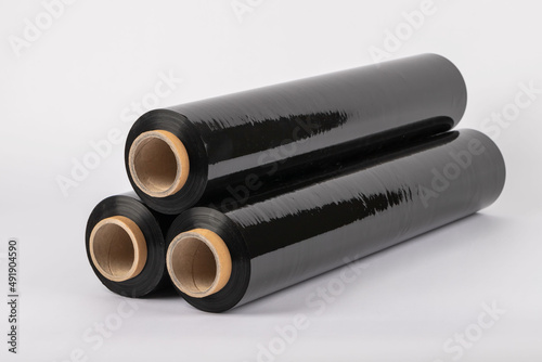 Roll of plastic cling film with black wrap. how long the roll of cling film can stretch is shown. It stands in an isolated environment. It is used in the packaging of products.
