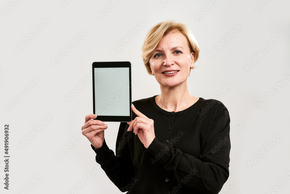 Smiling mature caucasian woman show digital tablet