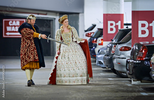 Stand back mlady, Ill deal with these creatures. A king and queen in a parking garage viewing cars suspiciously. photo