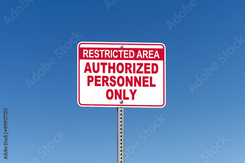Restricted Area, Authorized Personnel Only, street sign with blue sky background
