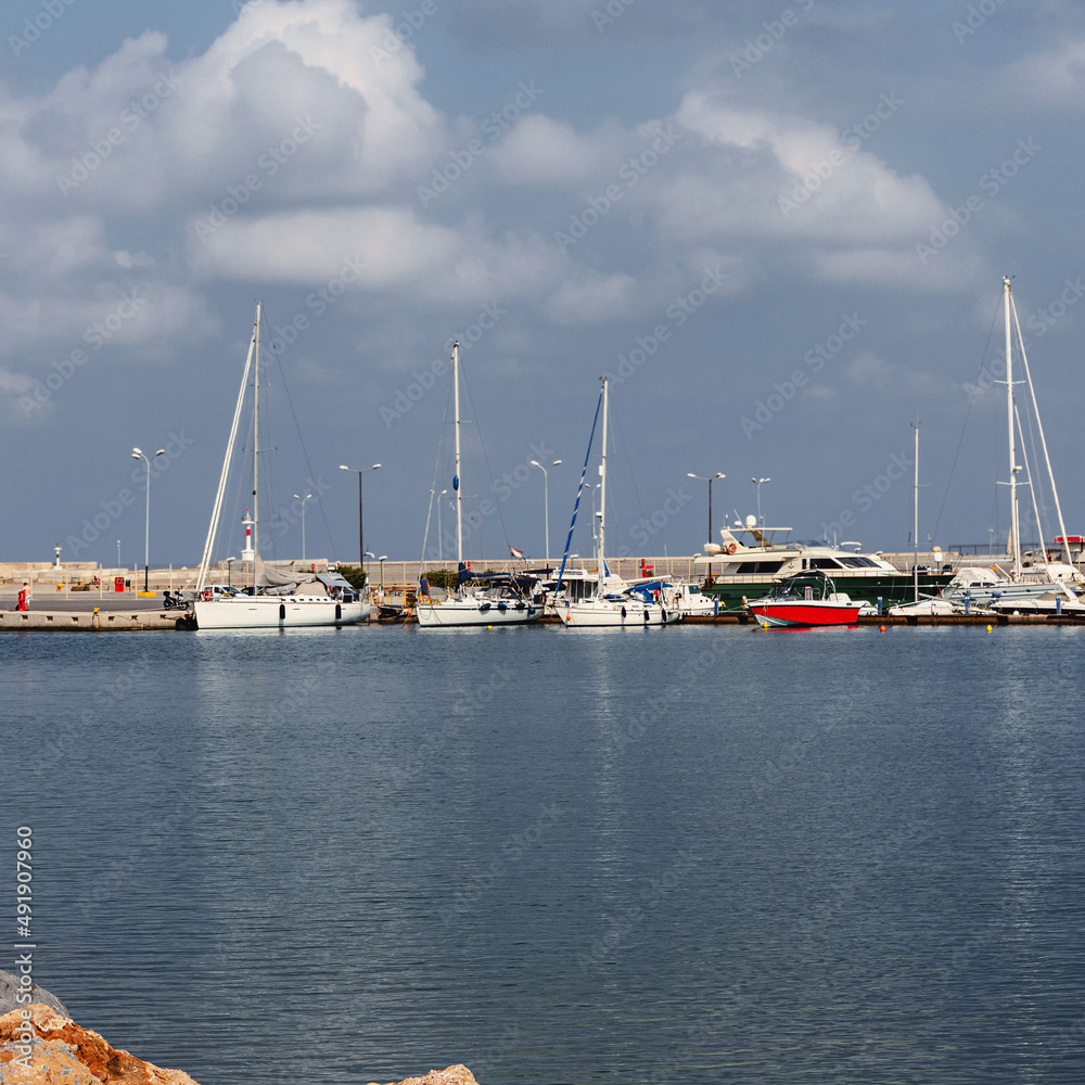 small sailing boats are parked in the seaport of a Greek town Rethymnon