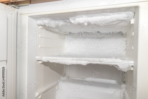 Ice inside a fridge. Defrosting freezer. photo