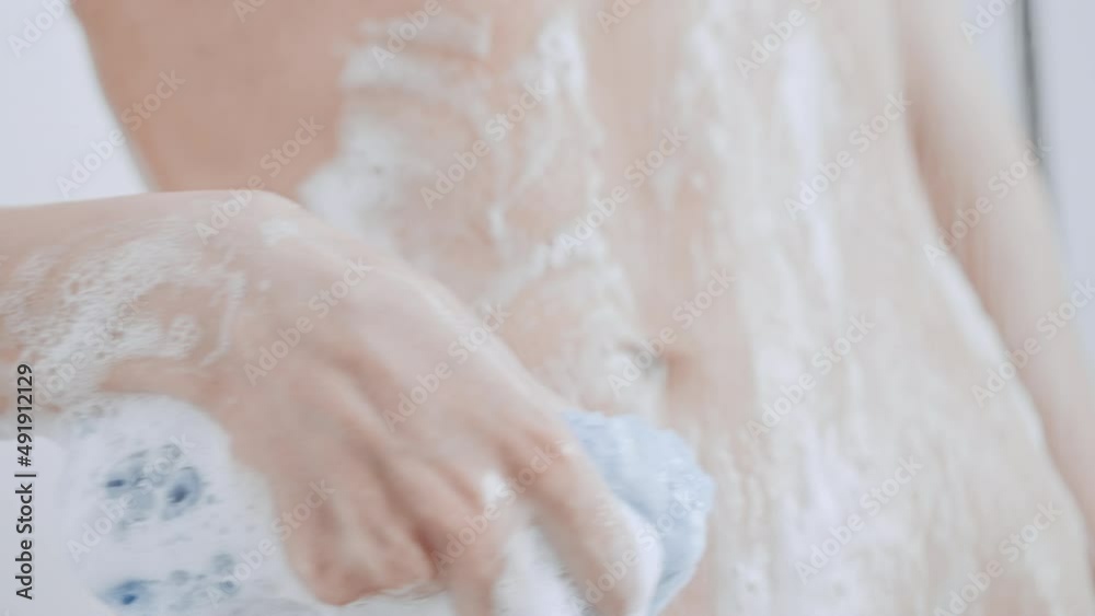 close up caucasian female take shower foam flows down the slim stomach hygiene and skin care