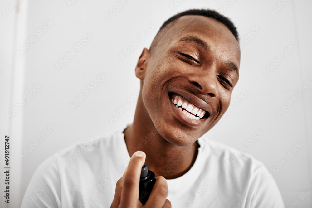 We are love smelling good. Shot of a young man spraying himself with deodorant. We are love smelling good. Shot of a young man spraying himself with deodorant.