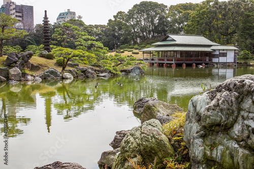 Pagoda on island and small pines on it   and teahouse on the shore of lake in the Kiyosumi Teien in Tokyo photo