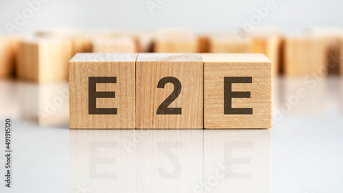 e2e - letters on wooden cubes. business as usual concept image. front view photo