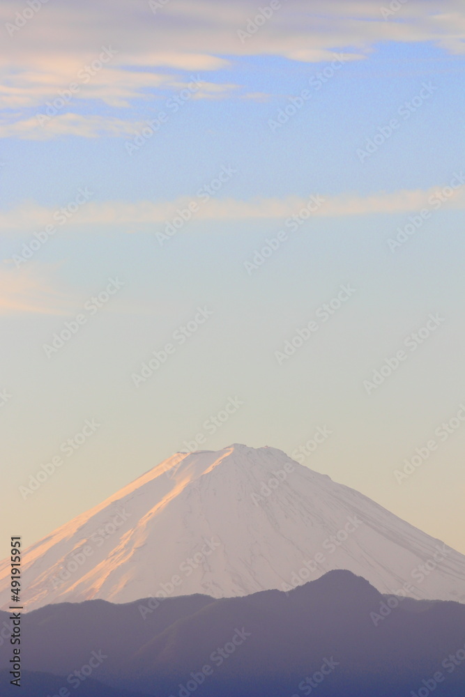 世界遺産　日本の富士山が 朝日が雪に反射して ピンク色の山と雲と空がとても綺麗で