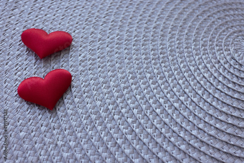 Two hearts on a grey wicker background.