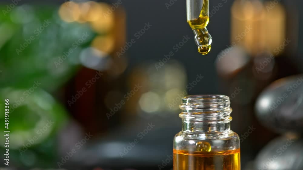 Super Slow Motion Shot of Oily Essence Drop into Phial on Dark Background at 1000fps. Super Slow Motion Shot of Oily Essence Drop into Phial on Dark Background at 1000fps.