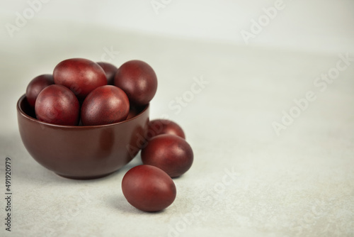 Dark rustic eggs in deep dark dish on a white background