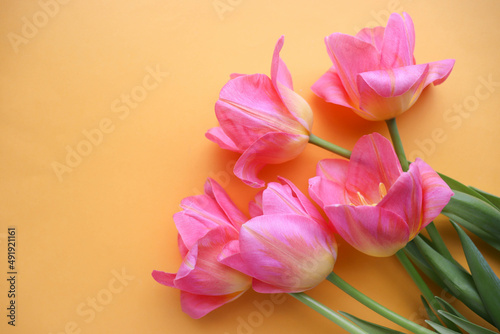 greeting card layout. bouquet of pink tulips on a yellow background and space for text