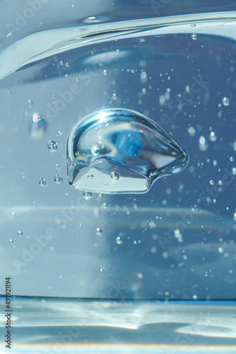 Bubbles of air or oxygen in water or gel. Can also represent a molecule or oil particle in a transparent liquid. Round and blue floating bubbles similar to hyaluronic acid. Shallow depth of field.