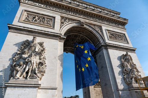фотографія Paris, France: European Union flag flying in the wind under the Arc de Triomphe