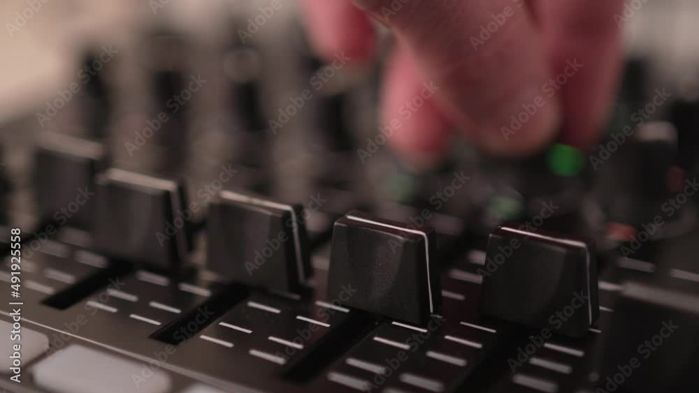 DJ Audio Mixer Adjusting Faders and Sliders on the Console