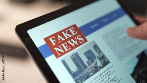 Reading Fake News Online on a Touch Screen Tablet Closeup photo