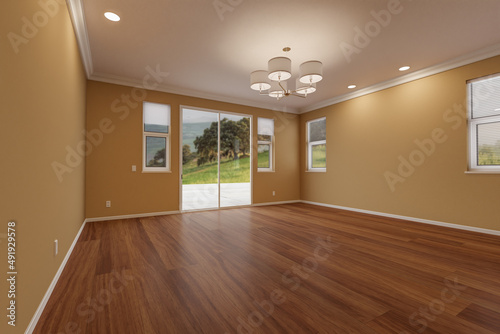 Newly Remodeled Room of House with Finished Wood Floors  Moulding  Dark Tan Paint and Ceiling Lights.