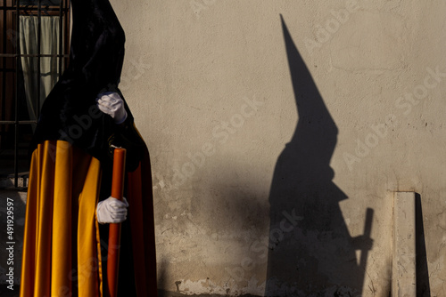 Foto detail of the shadow of a nazarene on the wall during the holy week in sevilla, andalucia, spain