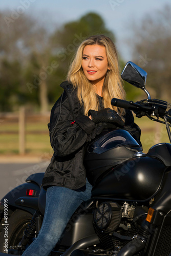 A Lovely Blonde Model Enjoys The Outdoor Weather While Posing With Her Motorcycle © Grindstone Media Grp