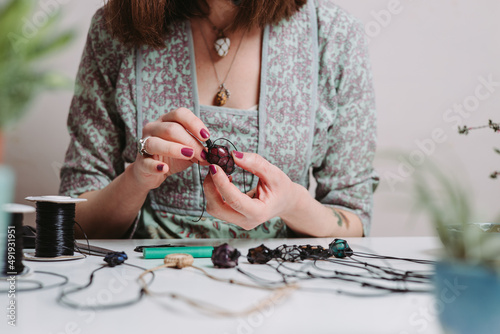 Photos Woman hands making handmade gemstone jewellery, home workshop